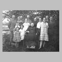 050-0019 Grossmutter Gudde, 20 Jahre an den Rollstuhl gefesselt, mit der ganzen Familie im Garten in Koddien.jpg
